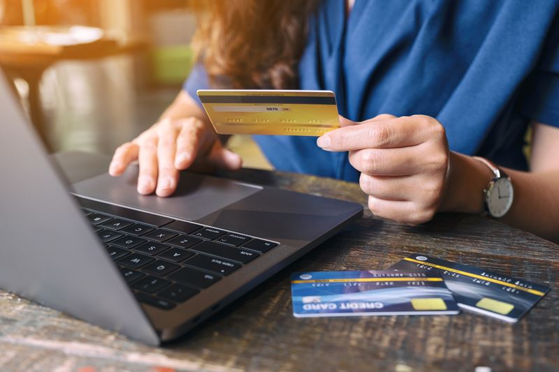 Woman using Debit Cards on Computer